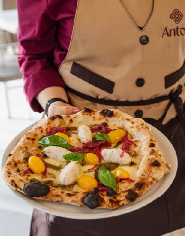 Una pizza appena sfornata portata in sala